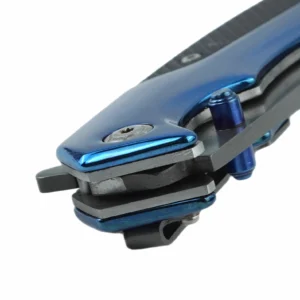 Close-up view of a folding knife pivot and blue thumb stud mechanism isolated on white background. SKU: KL-OD-SS-006.