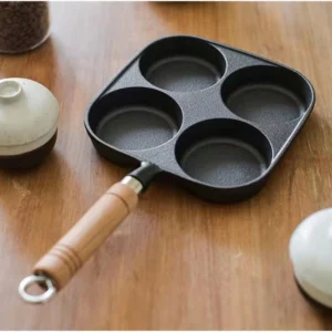 4-cup cast iron egg pan with wooden handle displayed on wooden tabletop KL-KA-GAD-002