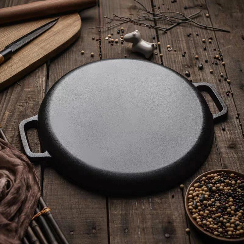 Pre-seasoned cast iron pizza pan with dual handles displayed on wooden tabletop KL-KA-BBQ-011