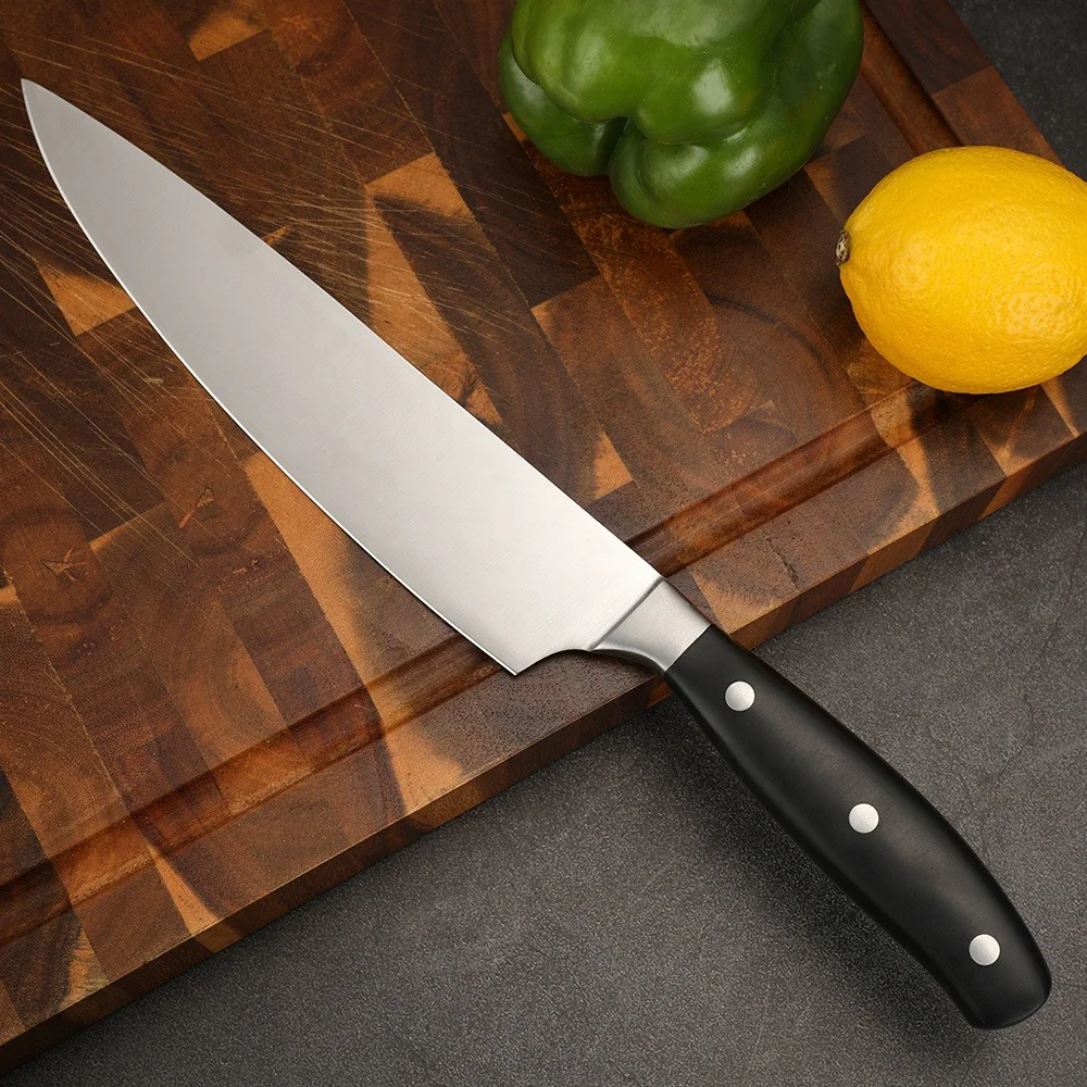 Forged chef knife with black handle displayed on wooden tabletop with vegetables KL-KN-SS-021