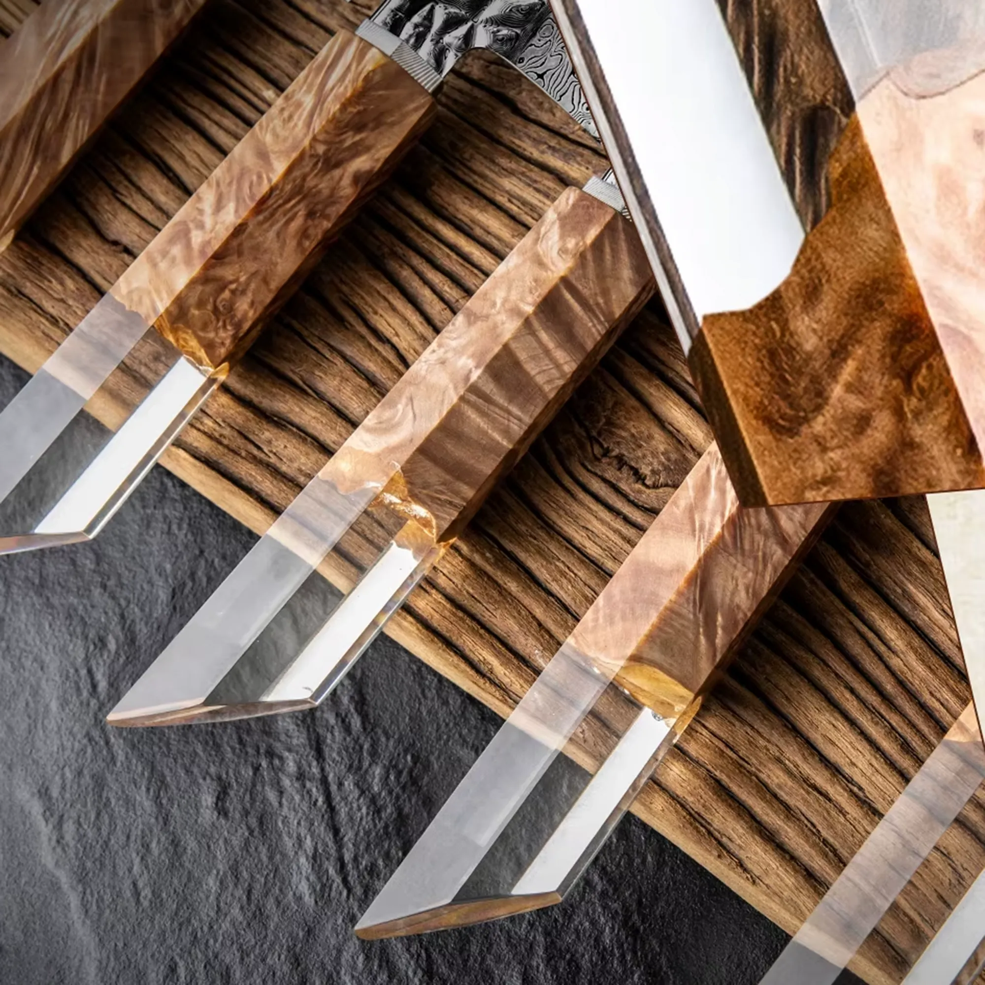 Close-up of clear acrylic resin knife handles with embedded burl wood on workbench setting. SKU: KL-KK-DS-004