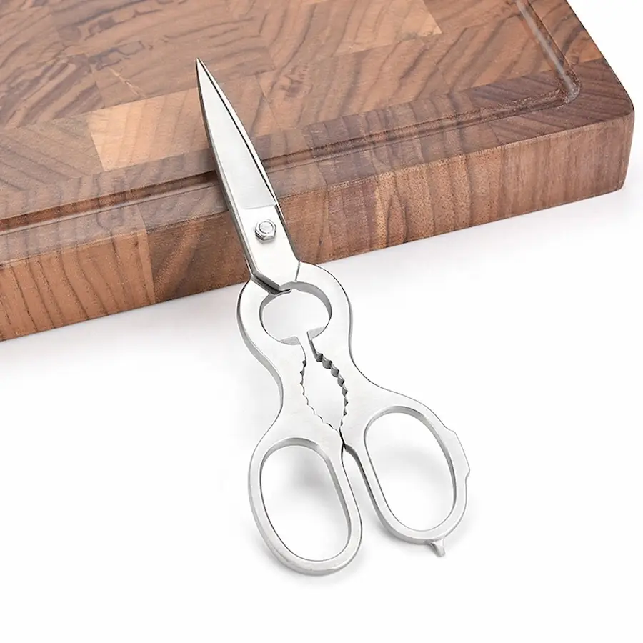 All-stainless steel multi-function kitchen shears leaning on a wooden cutting board background. KL-SC-PR-011