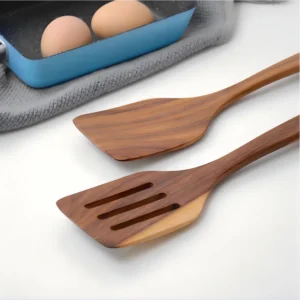 Natural wood slotted spatula and solid turner set on workbench setting. KL-KA-GAD-006