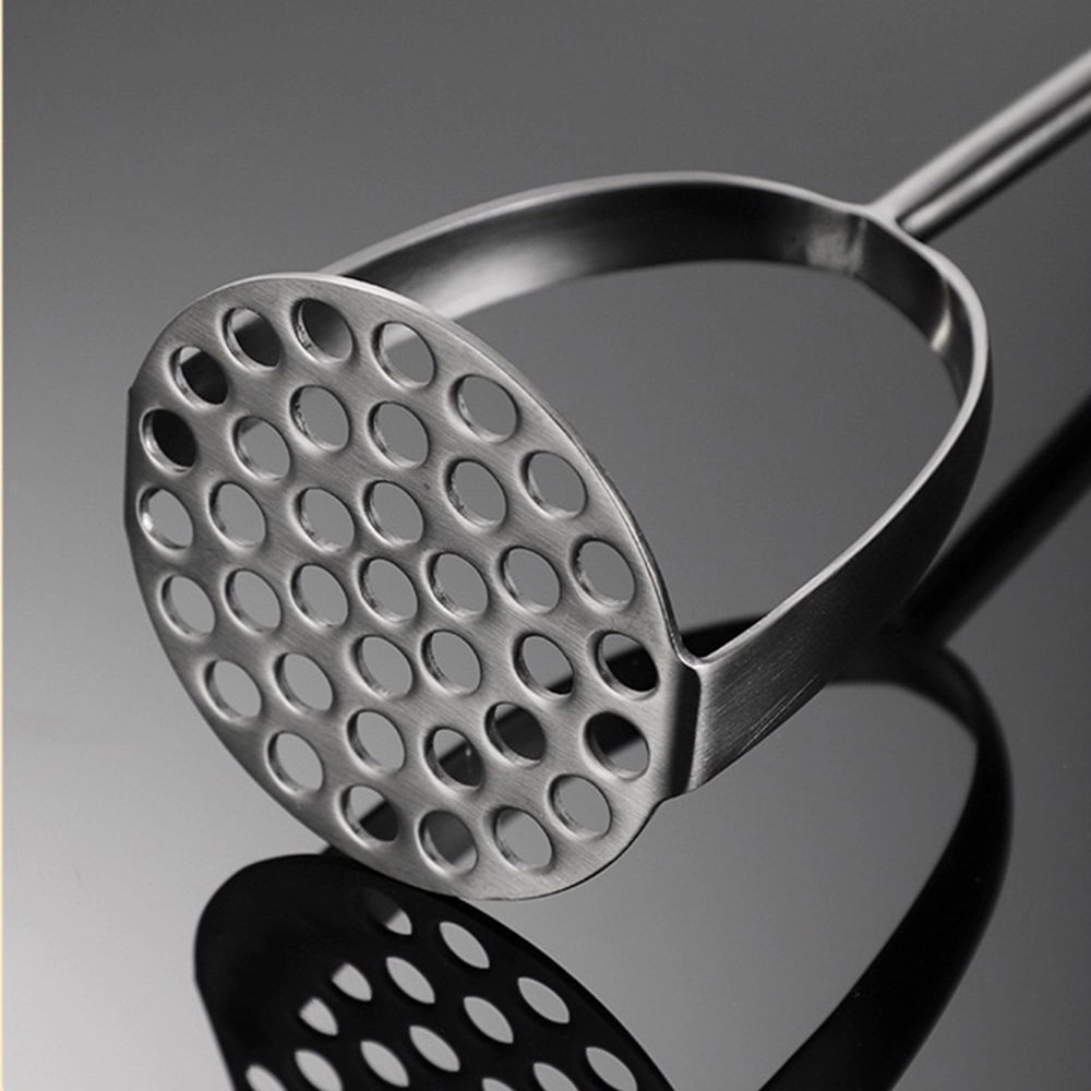 Stainless steel potato masher perforated head close up on reflective surface KL-KA-GAD-001