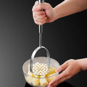 Stainless steel potato masher held in hand for scale while mashing potatoes KL-KA-GAD-001