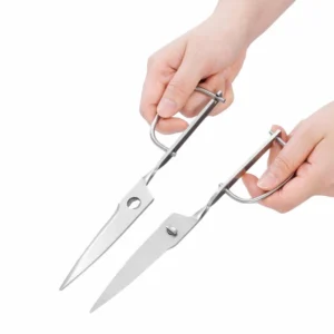 Separable stainless steel kitchen scissors held in hand for scale to show detachable blades, SKU KL-SC-PR-013.