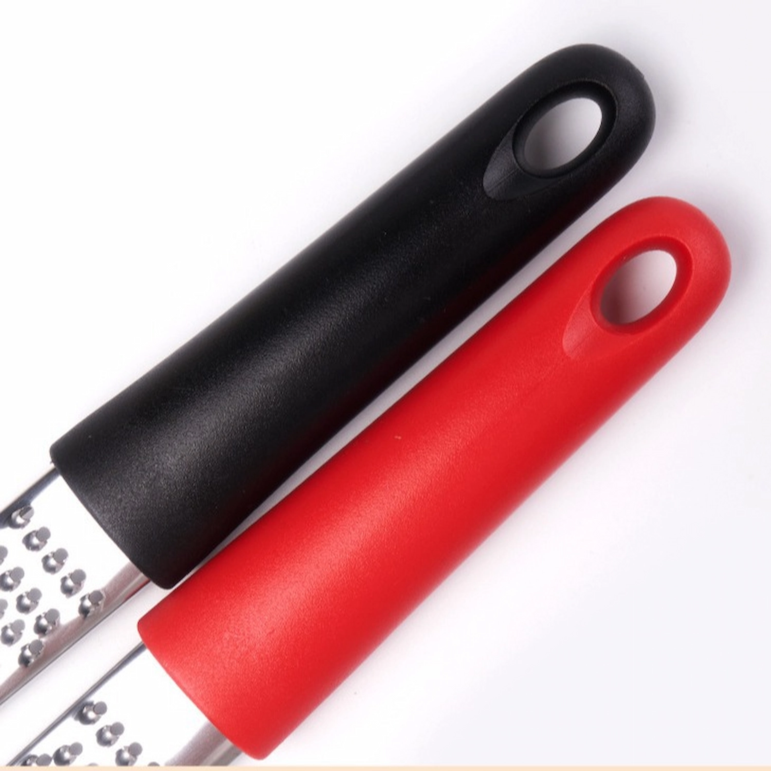 Close-up of black and red polypropylene handles on stainless steel fine grater zesters isolated on white background KL-KA-GR-001