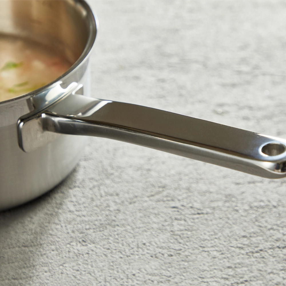 Stainless steel saucepan ergonomic long handle close up on workbench setting KL-KA-CU-002