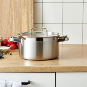 Stainless steel stock pot with lid displayed on wooden tabletop in kitchen environment KL-KA-CU-001