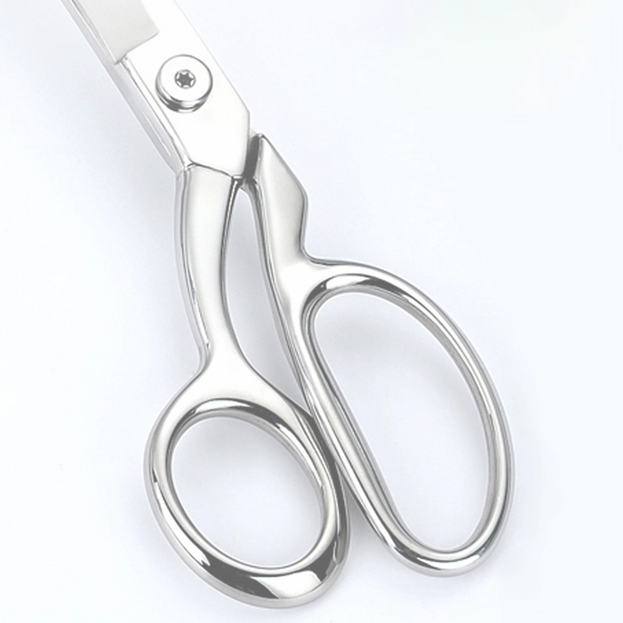A detailed close-up of the polished mirror finish on the asymmetric handles of tailor scissors, SKU: KL-SC-HC-001.